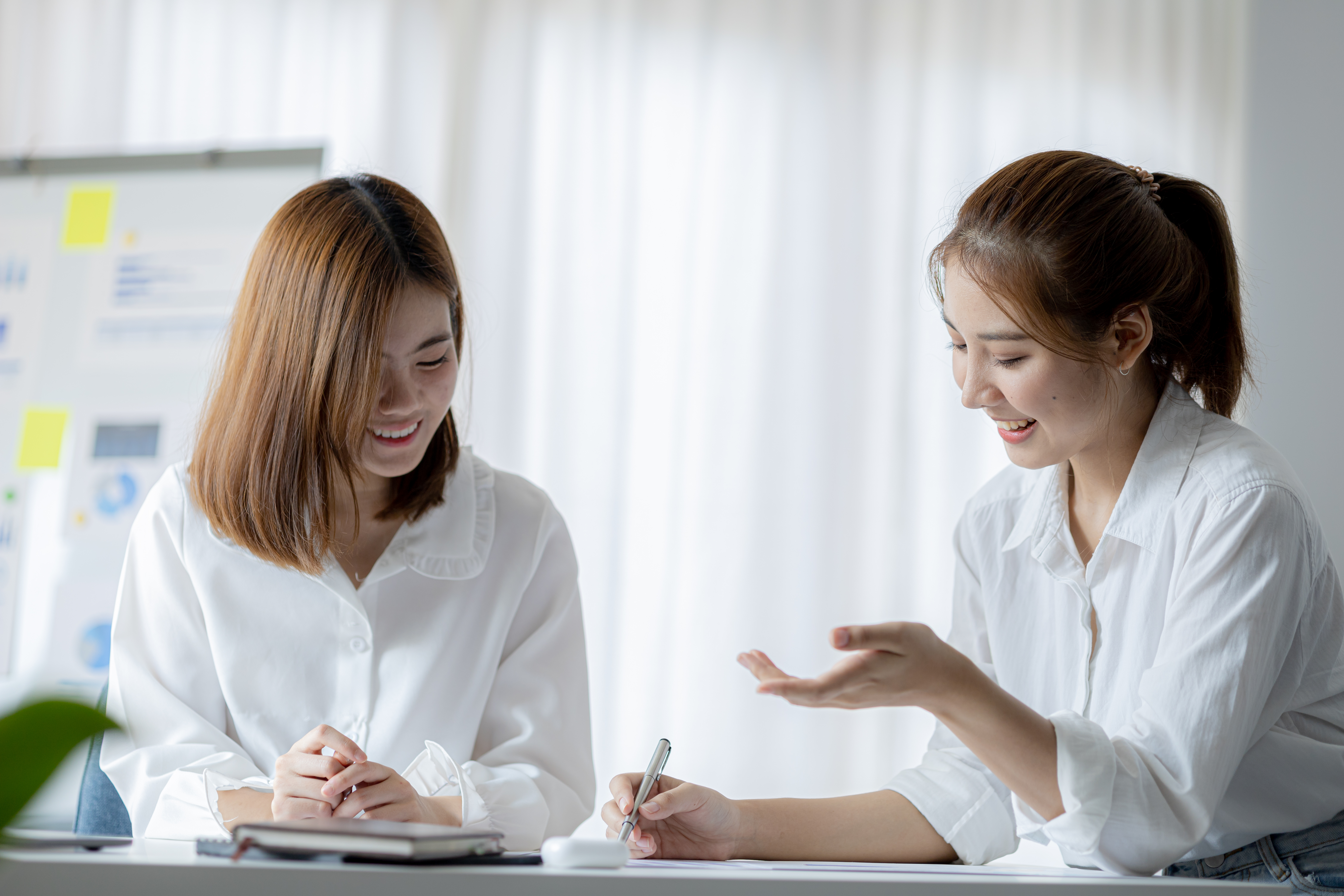 밝은 실내에서 마주 앉아 웃으며 대화하는 두 여성, 카페나 상담 자리처럼 일상 속 만남과 대화 장면을 표현한 참고 이미지